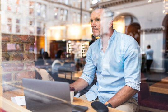 Businessman sitting with laptop in cafe