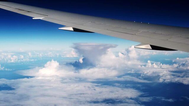 Air plane window view time lapse clouds and blue sunny sky, Loop of white clouds over blue sky with sun Rays, Aerial view, drone shooting clouds motion time, nature blue sky a white cleat weather. 4K.