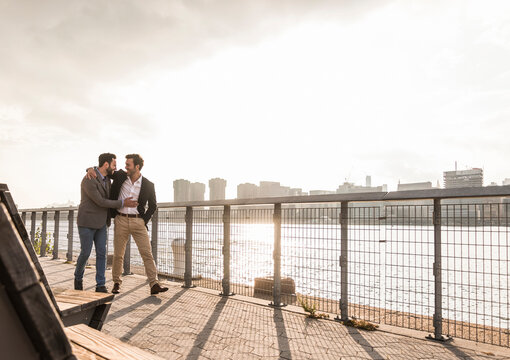Happy business colleagues walking by Hudson river in New York City