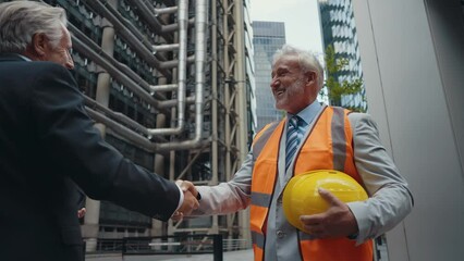 Cinematic image of senior businessmen at work in London. Business man entrepreneur making deals with partners over future investments. Concepts about finance, entrepreneurship and lifestyle.