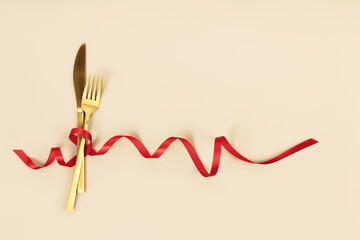 Fork and knife tied with a red ribbon. Romantic dinner. Valentine's Day
