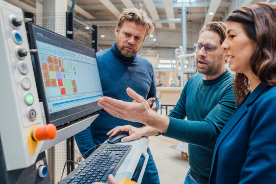 Businessman discussing with colleagues over computer and in industry