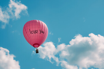 Fototapeta premium pink hot air balloon with love you text on it, love is in the air