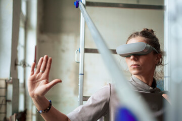 Woman wearing VR simulator gesturing at art studio