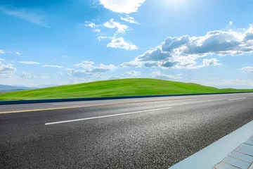  Asphalt road and green meadow with mountain nature landscape under blue sky © ABCDstock