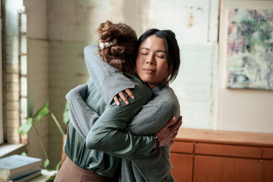 Women hugging each other at art studio - Powered by Adobe