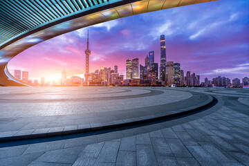 Empty square floor and bridge with modern city buildings at sunrise in Shanghai