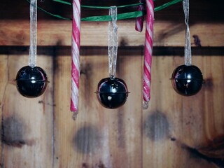 Silver Christmas baubles bells and candy on rustic wooden background