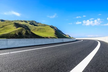 Rolgordijnen Asphalt highway road and green mountain nature landscape under blue sky © ABCDstock