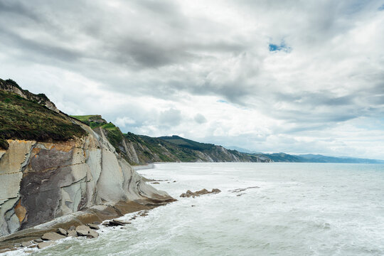 Rocky coastline at Itzurun under cloudy sky