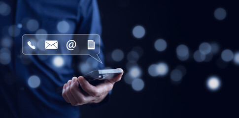 Communication and Contact us or Customer support hotline people connect. Hand using a laptop and touching on virtual screen contact icons, email and address, live chat with internet wifi.