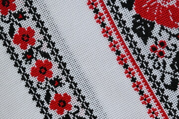 Overhead view of a fragment of a Ukrainian embroidered towel, oak leaves, viburnum, black and red...