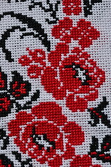 black red Ukrainian embroidery on white canvas, a fragment of a decorated wedding towel, flowers embroidered on white canvas 