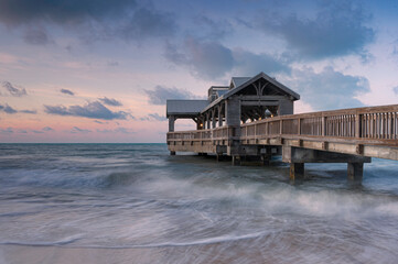 Wooden pier, located in Key West, Florida, reaching out into the calm tropical waters of the ocean,...
