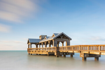 Wooden pier, located in Key West, Florida, reaching out into the calm tropical waters of the...