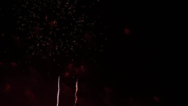 Bursting colorful lights filling the night sky at a beachfront in a popular tourist destination in Southeast Asia during an international fireworks festival.