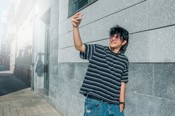 teenager on the street taking a selfie or live video with the mobile phone