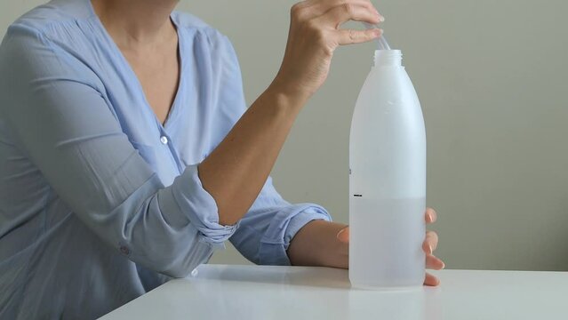 Woman using bubble PEP bottle device blowing for asthma, lungs and airways