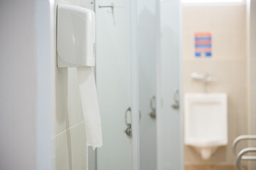 Selective focus toilet tissue paper in white box for cleaning hand on white wall background.