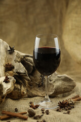 Glass of red wine with spice. Cloth background with copy space