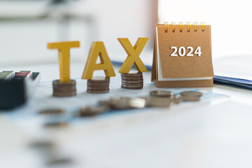 Tax golden wooden text and the number 2024 on the calendar. Pay tax in 2024 years. The new year...
