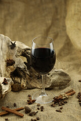 Glass of red wine with spice. Cloth background with copy space