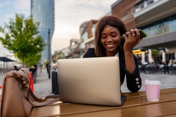 In the tranquil outdoors, the businesswoman of color maximizes her productivity, simultaneously...