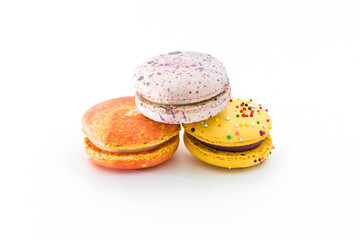 Sweet colorful yummy macarons isolated on white background. Brightly colored stacked macaroons. Tasty macaron. Three multi-colored orange, pink and yellow macaroons. French pastry, food concept