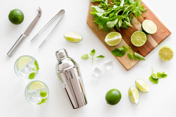 Bartender desktop with utensils and mojito cocktail. Lime with mint and ice cubes, top view