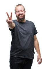 Naklejka premium Young caucasian hipster man over isolated background smiling with happy face winking at the camera doing victory sign. Number two.