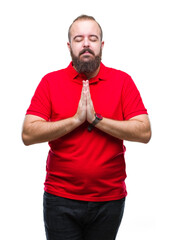 Young caucasian hipster man wearing red shirt over isolated background praying with hands together...