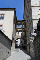 Summer view of a quaint back street with covered walk way in the historic old town of Brig-Glis, Valais, in Switzerland.