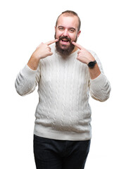 Fototapeta premium Young caucasian hipster man wearing winter sweater over isolated background smiling confident showing and pointing with fingers teeth and mouth. Health concept.