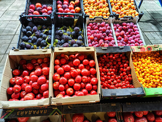 Yellow and orange tomatoes lie on a wooden counter in a local farm shop