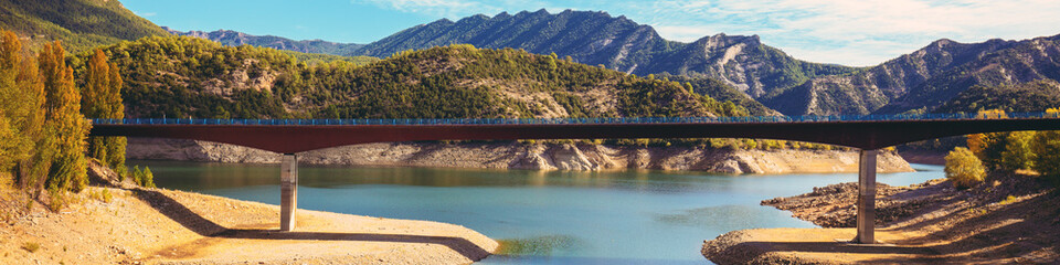 Mountain landscape. Road bridge over mountain river. Bridge of Saint Ermengol. Oliana Reservoir, Lleida, Spain. Horizontal banner