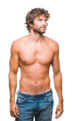 Fototapeta premium Handsome hispanic model man sexy and shirtless over isolated background looking away to side with smile on face, natural expression. Laughing confident.