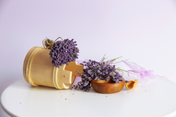 Bouquets of lavender flowers and wooden decor and organza sachet bags still-life on white table...