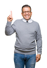 Middle age bussines arab man wearing glasses over isolated background showing and pointing up with finger number one while smiling confident and happy.