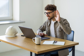 Obraz premium Successful young man looking on laptop video call while working at home office