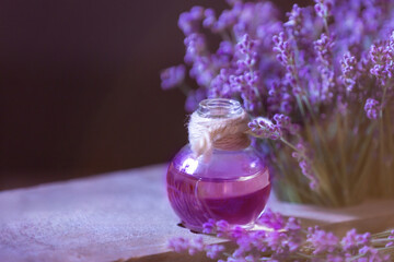 Obraz na płótnie Canvas Herbal oil and lavender flowers still-life on wooden background