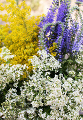 Bouquet of wild flowers. Small white, yellow, blue flowers. Floral background.