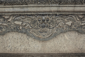 Intricate dragon in cloud carvings on ancient stone stele at historical Tomb of Khai Dinh site, Vietnam