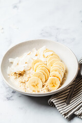 Overnight oatmeal with banana and coconut chips.