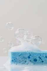 Blue sponge and sparkling soap bubbles on white background. Cleaning concept, banner for eco-friendly article or for cleaning service.