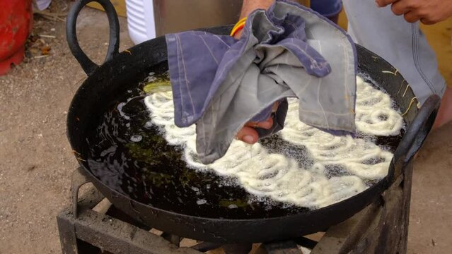 Indian Famous Street food Jalebi, is a popular sweet snack in south and west Asia, Delicious jalebi frying in oil pan.