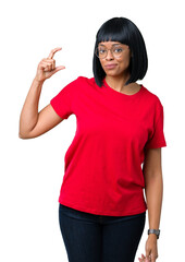 Beautiful young african american woman wearing glasses over isolated background smiling and confident gesturing with hand doing size sign with fingers while looking and the camera. Measure concept.