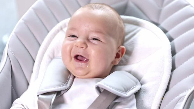 Newborn baby laughing and smiling, cute situation, positive emotions of the baby, healthcare concept