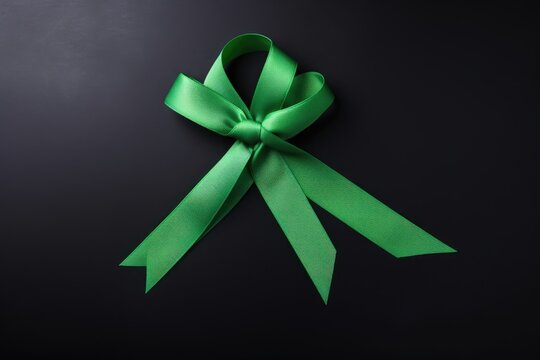 Green ribbon on black background. World bipolar day. Mental health awareness day, Depression, Cerebral palsy. World kidney day.