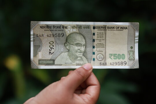 holding 500 Rupee indian note in hand