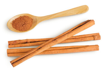 Cinnamon sticks with powder in wooden spoon isolated on white background with full depth of field. Top view. Flat lay.